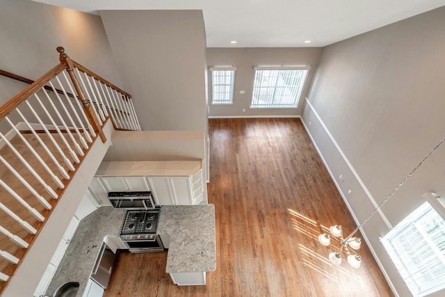 staircase featuring recessed lighting, baseboards, and wood finished floors