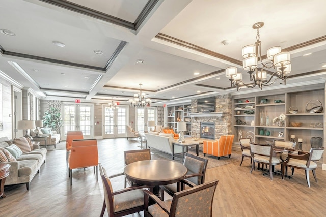 dining room featuring a chandelier, light wood-style flooring, a fireplace, and ornamental molding