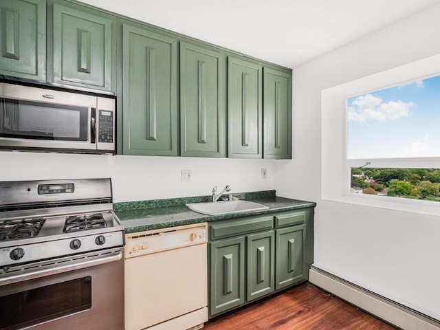 kitchen with stainless steel appliances, a baseboard radiator, a sink, and dark countertops