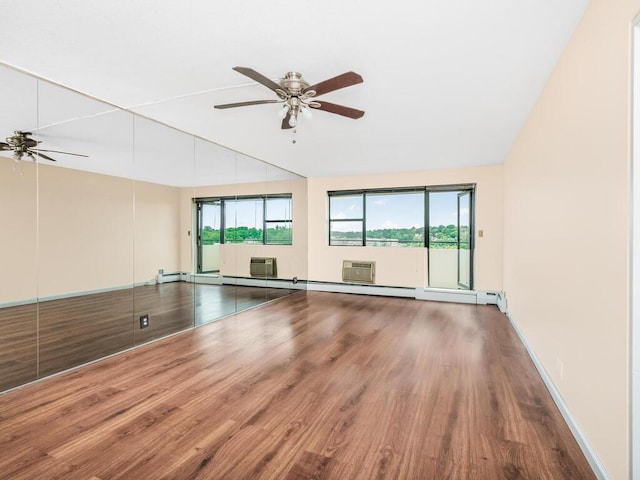 spare room with a baseboard radiator, an AC wall unit, vaulted ceiling, ceiling fan, and wood finished floors