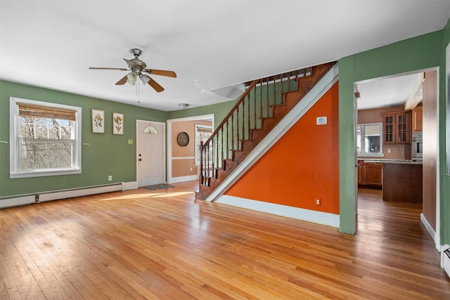 foyer entrance featuring light wood-type flooring, plenty of natural light, baseboards, and stairs