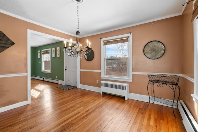 unfurnished dining area featuring a baseboard radiator, radiator, a baseboard heating unit, light wood-type flooring, and plenty of natural light