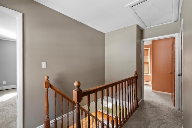 corridor with attic access, light colored carpet, and an upstairs landing