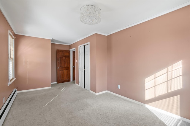 empty room featuring light colored carpet, a baseboard heating unit, a healthy amount of sunlight, baseboards, and crown molding