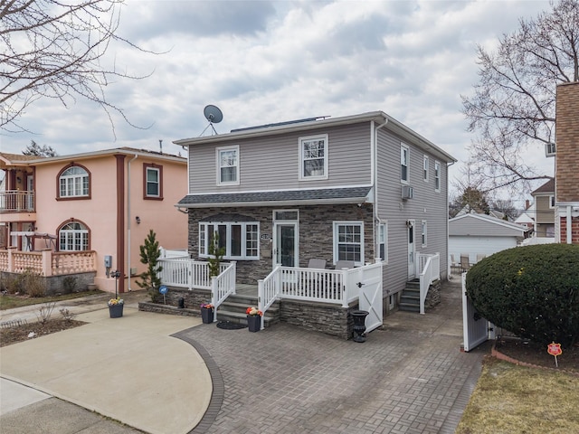 back of house featuring stone siding and a patio