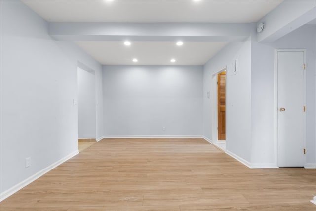 spare room with baseboards, light wood finished floors, and recessed lighting