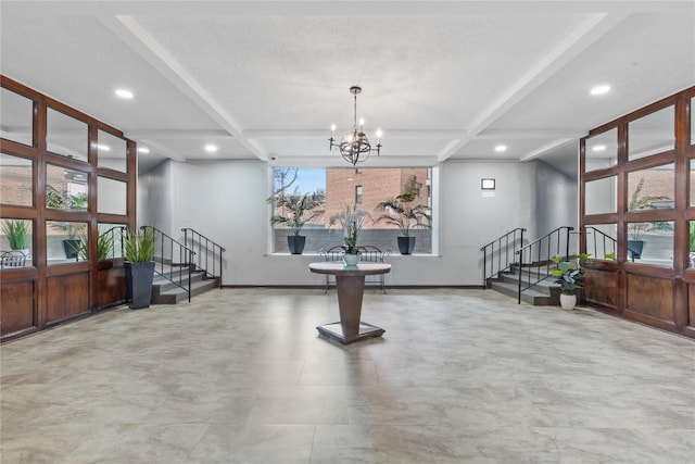 exercise area with a chandelier, a textured ceiling, recessed lighting, coffered ceiling, and baseboards