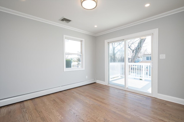 empty room featuring a healthy amount of sunlight, a baseboard radiator, visible vents, and ornamental molding