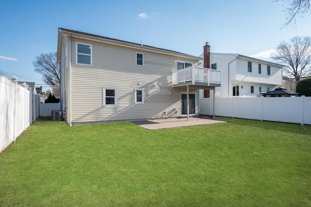 rear view of house with a patio area, a fenced backyard, and a yard