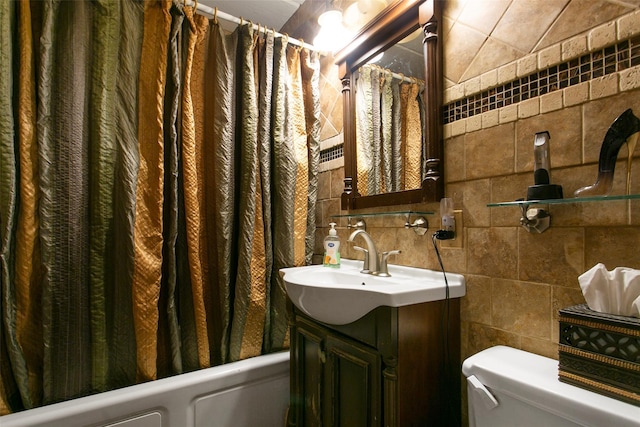 bathroom featuring shower / bath combination with curtain, vanity, toilet, and tile walls