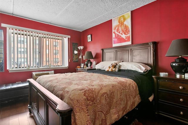 bedroom featuring a wall unit AC and dark wood finished floors