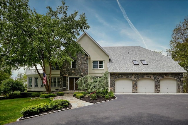 view of front of home with stone siding, stucco siding, aphalt driveway, an attached garage, and a front yard