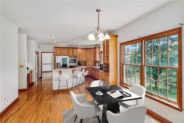 dining room featuring recessed lighting, baseboards, a notable chandelier, and light wood finished floors