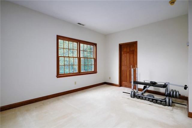 workout room featuring visible vents, light carpet, and baseboards