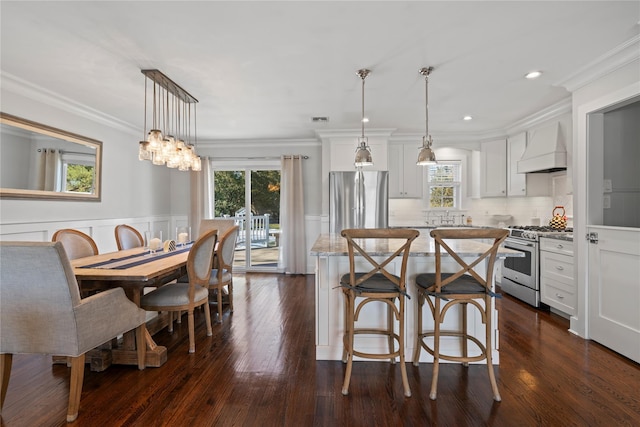 kitchen featuring stainless steel appliances, hanging light fixtures, custom exhaust hood, and white cabinetry