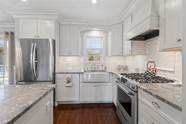 kitchen with appliances with stainless steel finishes, white cabinets, light stone counters, and custom exhaust hood