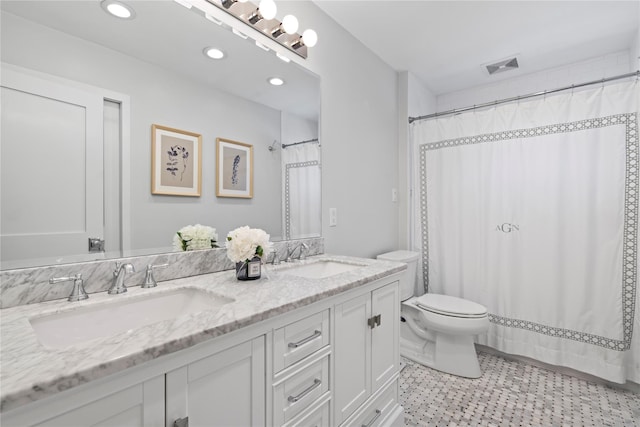 full bath with toilet, double vanity, a sink, and visible vents