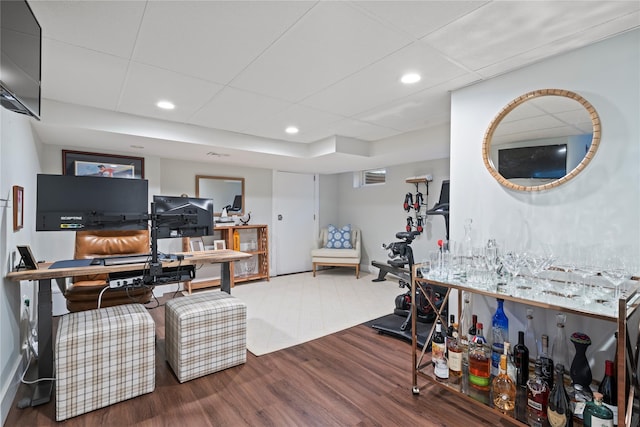 home office with recessed lighting, a drop ceiling, and wood finished floors