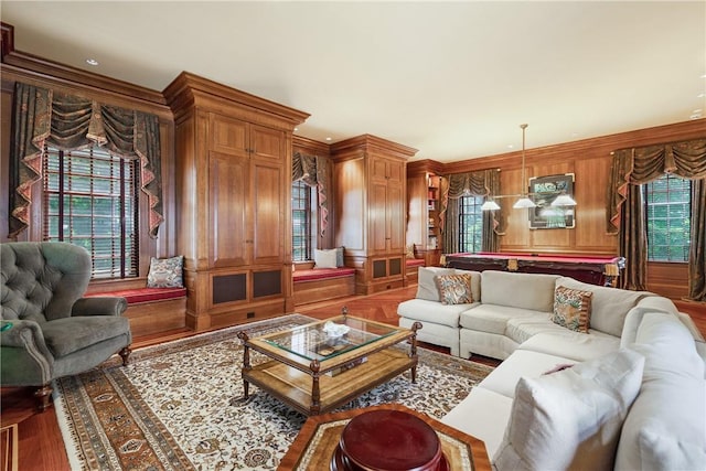 living area with billiards, wooden walls, crown molding, and wood finished floors