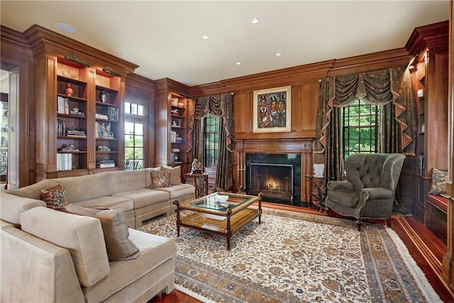 living room featuring ornamental molding, a premium fireplace, and wood finished floors