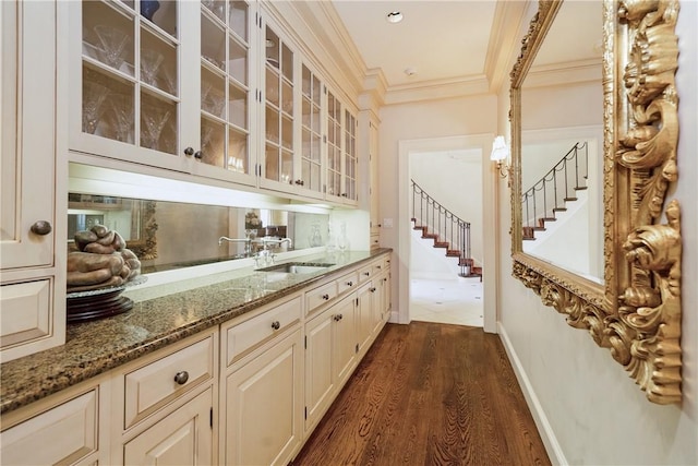 bar with baseboards, stairway, ornamental molding, dark wood-style flooring, and a sink