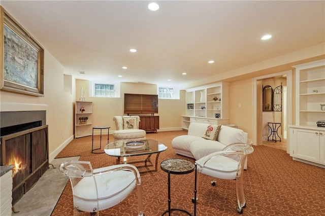 living area with a warm lit fireplace, recessed lighting, light carpet, and built in features