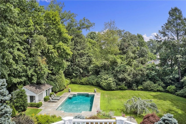 pool with a patio, a lawn, an outdoor structure, and an exterior structure