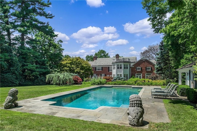 pool featuring a lawn and a patio