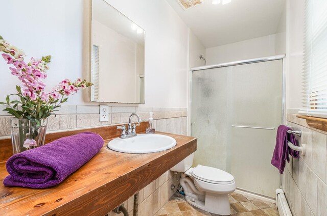 full bathroom featuring a sink, toilet, a shower stall, and baseboard heating