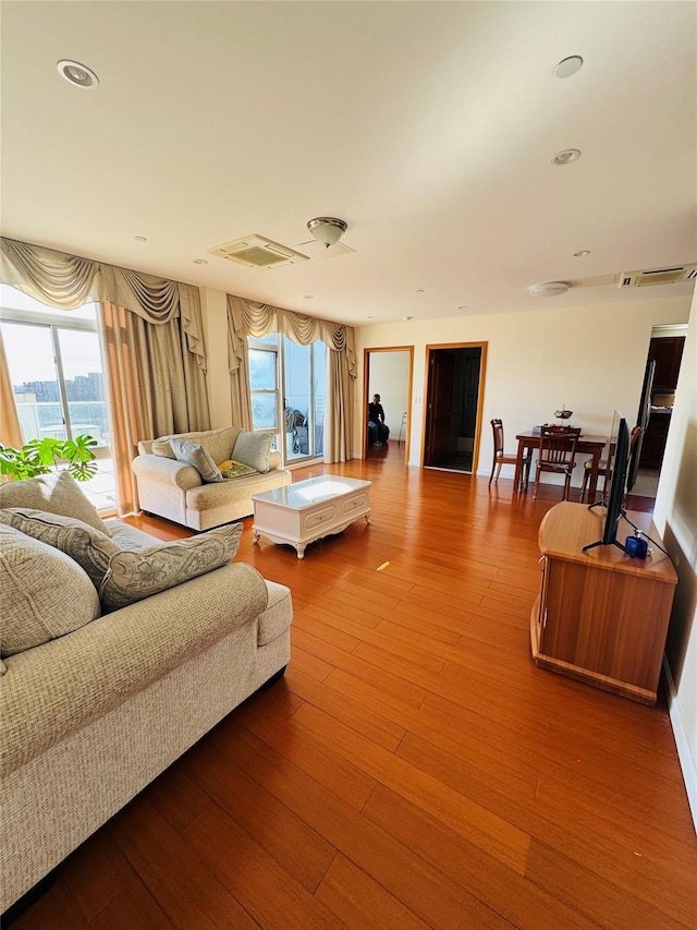 living room featuring wood finished floors, visible vents, and recessed lighting