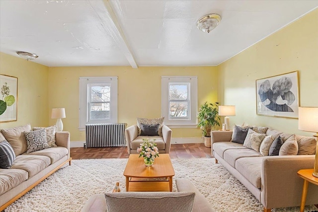 living area featuring beamed ceiling, radiator heating unit, plenty of natural light, and baseboards