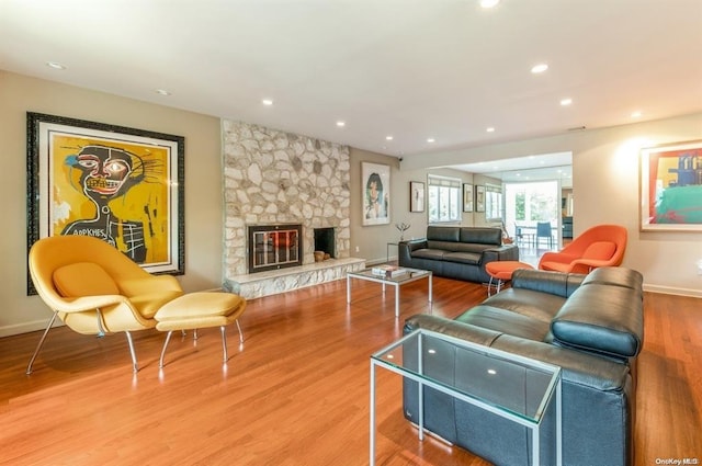 living area featuring baseboards, a fireplace, wood finished floors, and recessed lighting