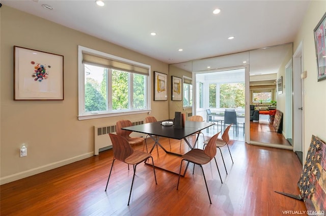 dining space with radiator, plenty of natural light, baseboards, and wood finished floors