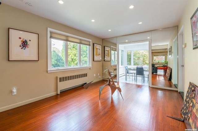 interior space featuring radiator heating unit, baseboards, wood finished floors, and recessed lighting