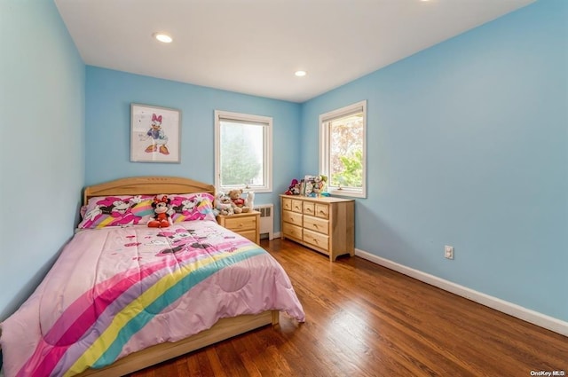 bedroom with radiator heating unit, recessed lighting, wood finished floors, and baseboards