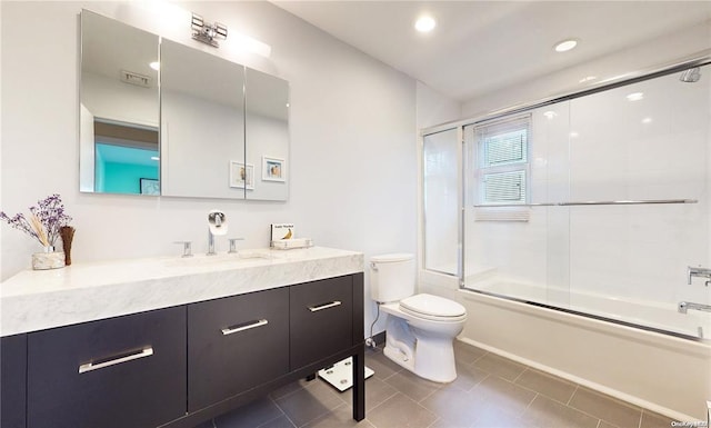 bathroom featuring recessed lighting, toilet, enclosed tub / shower combo, vanity, and tile patterned flooring