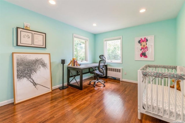 bedroom with radiator, baseboards, wood finished floors, and recessed lighting