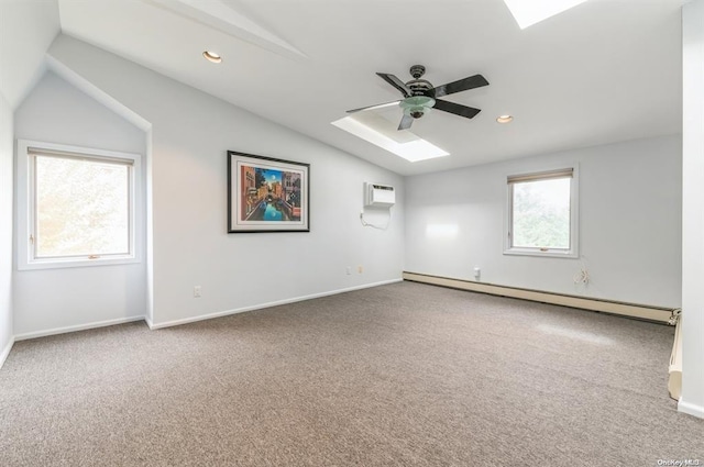 carpeted spare room featuring recessed lighting, a baseboard heating unit, a ceiling fan, an AC wall unit, and vaulted ceiling with skylight