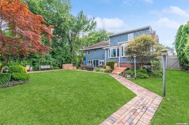 back of property with a patio, a lawn, fence, and a gate