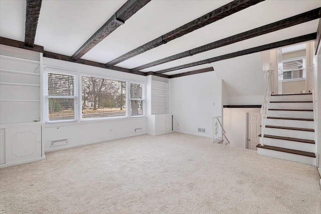 unfurnished living room featuring carpet, stairs, and beamed ceiling