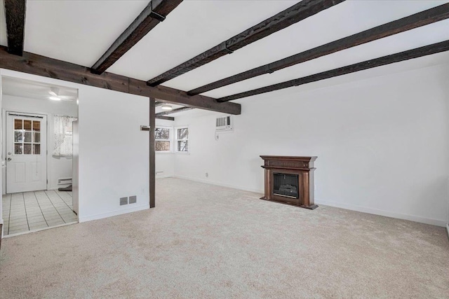 unfurnished living room with a fireplace, visible vents, carpet flooring, beamed ceiling, and baseboards