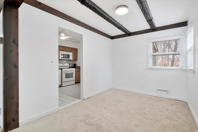 spare room with light colored carpet, a ceiling fan, baseboards, visible vents, and beam ceiling