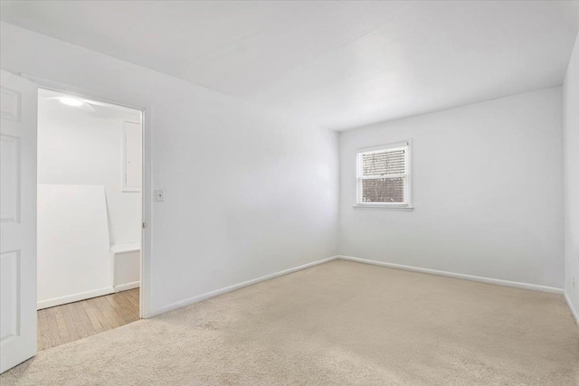 carpeted empty room featuring baseboards