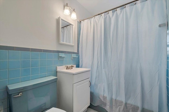 full bathroom with toilet, vanity, tile walls, wainscoting, and a shower with curtain