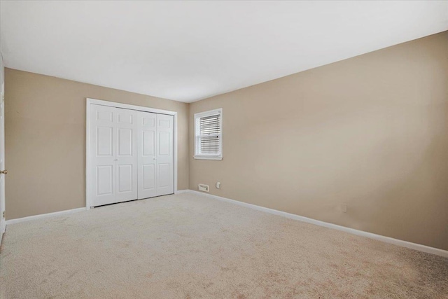 unfurnished bedroom featuring carpet floors, a closet, and baseboards