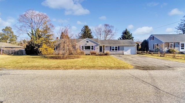 ranch-style house with driveway, a front lawn, and fence