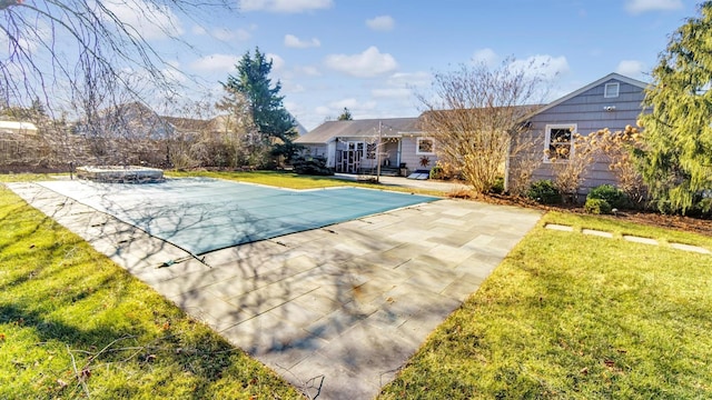 view of pool featuring a patio area, a covered pool, and a lawn