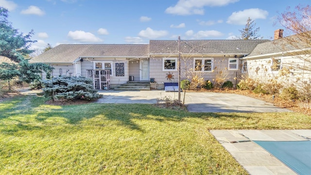 rear view of house featuring a lawn and a patio area