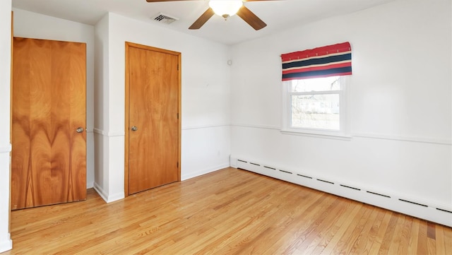 unfurnished bedroom featuring a ceiling fan, a baseboard radiator, visible vents, and light wood-style flooring