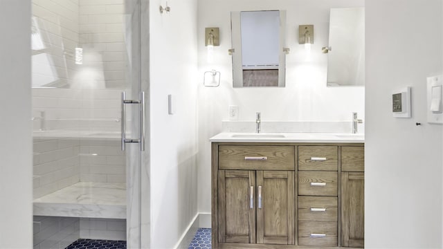 bathroom with double vanity, a stall shower, and a sink